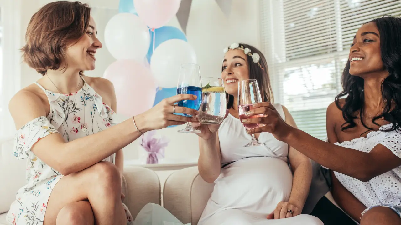 Três mulheres comemorando o chá de bebê.