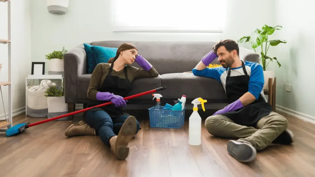 Lista de tarefas de casa: rotina de limpeza e organização Casal cansado após faxina.