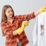 Mulher retirando ferrugem de roupa