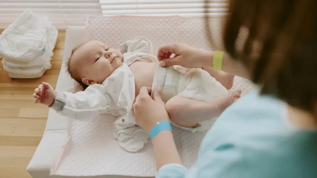 mãe trocando fralda de bebê