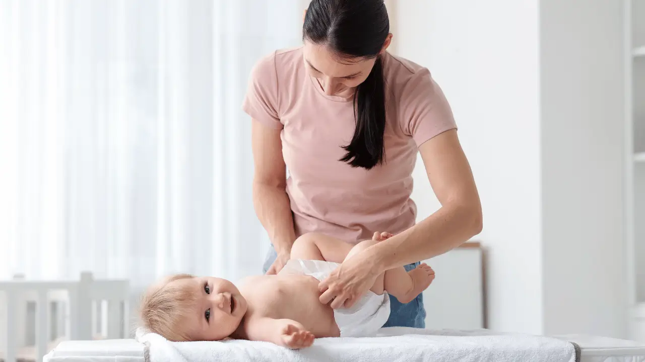 mãe trocando fralda de bebê