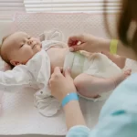 Mãe trocando fralda de bebê