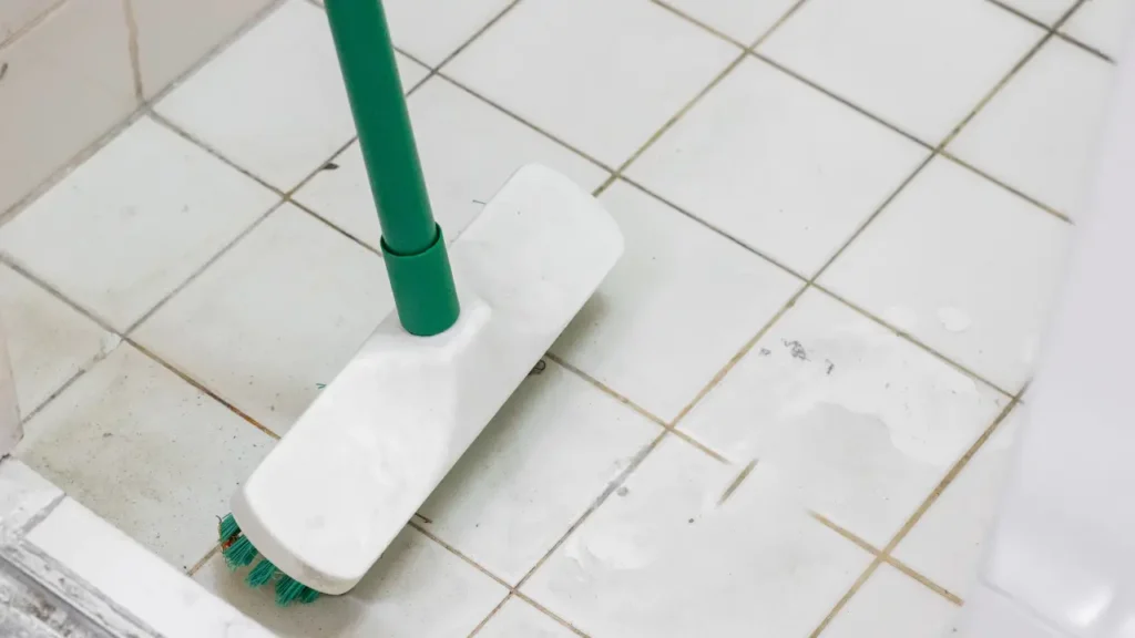 A imagem mostra um rodo a limpar um piso encardido.