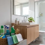 um banheiro limpo e um cesto com produtos de limpeza para banheiro