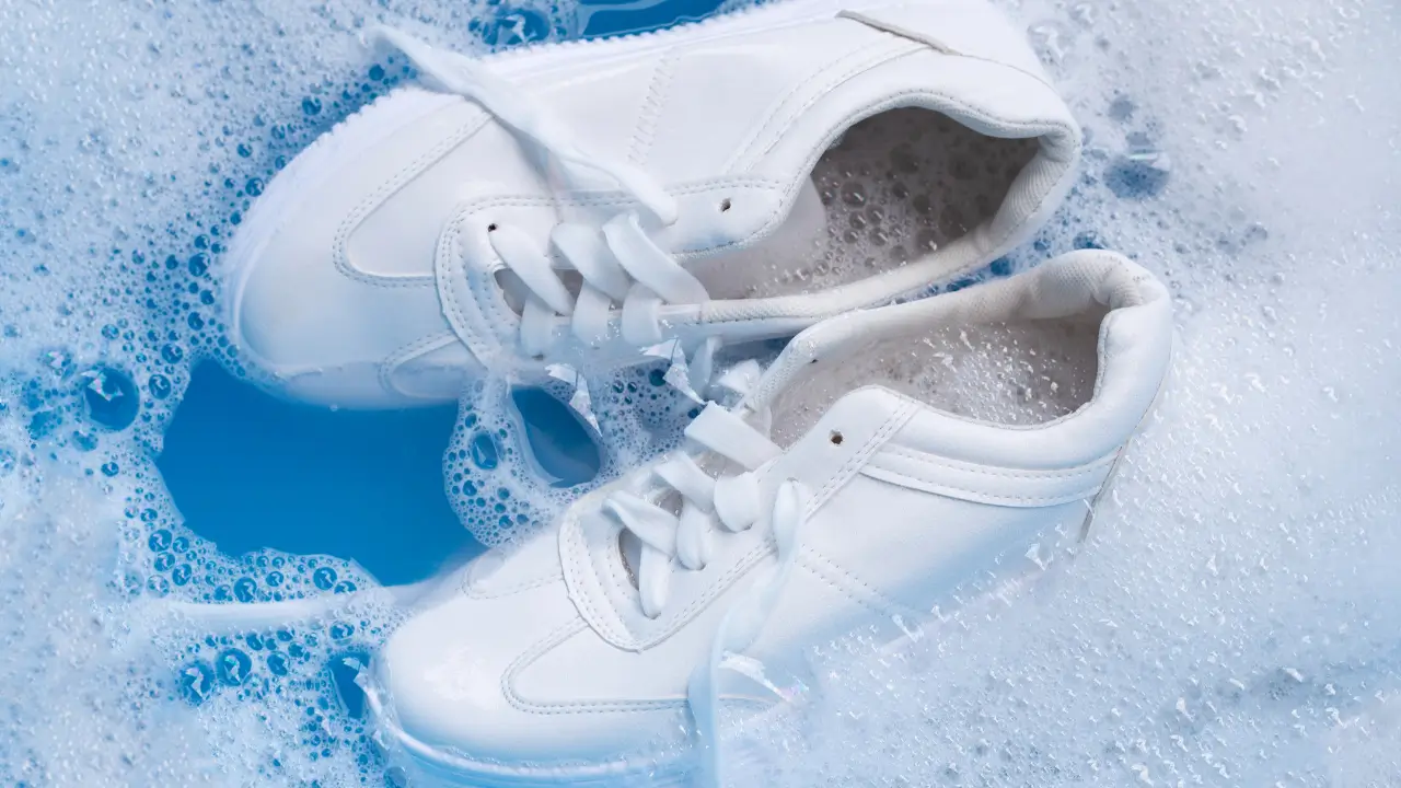 Um par de tenis branco sobre agua com sabão
