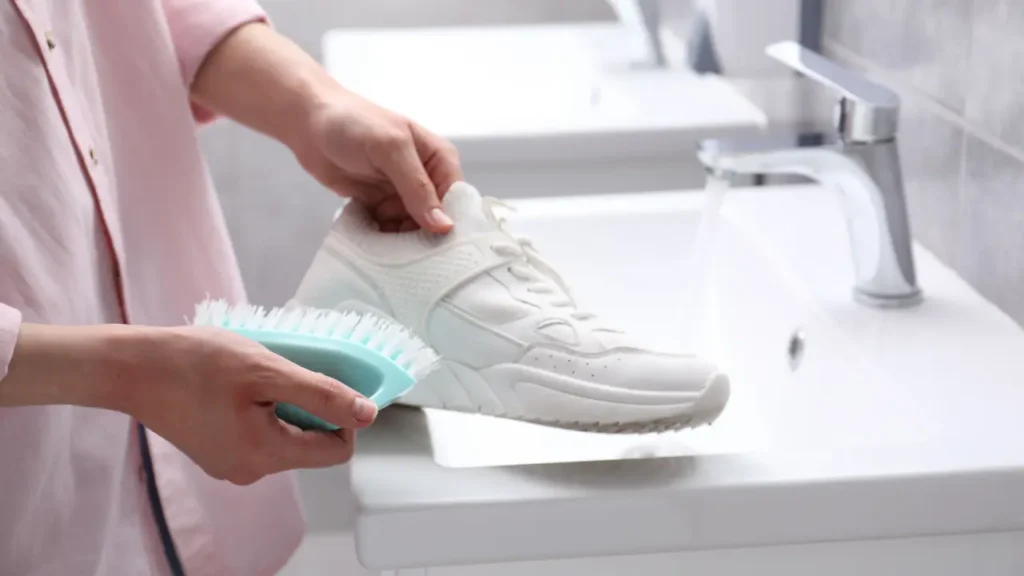 Uma pessoa limpando um tenis branco